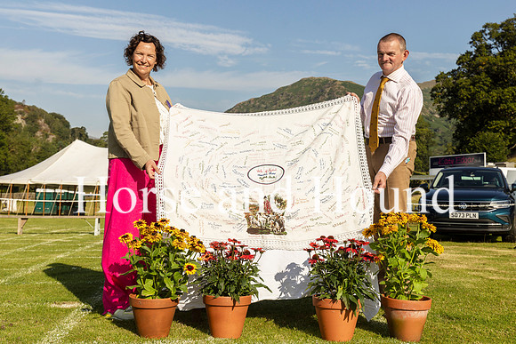 Rydale001 Chairman Claire Logan-Stephens and Nick Mowbray MFH holdingup the famous Dora Marley Tablecloth